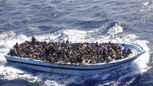 Ein überfülltes blaues Boot treibt auf dem offenen Meer.