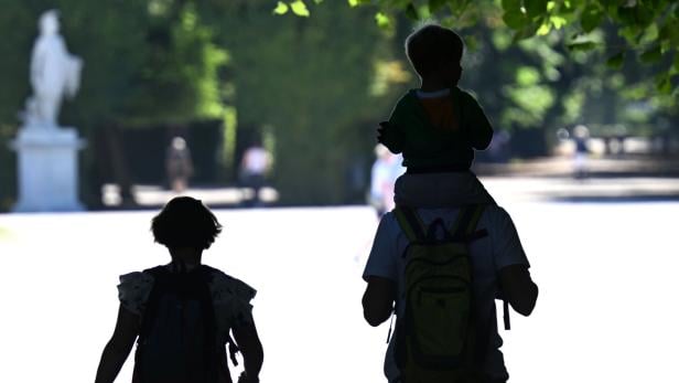 Mann trägt Kind auf den Schultern