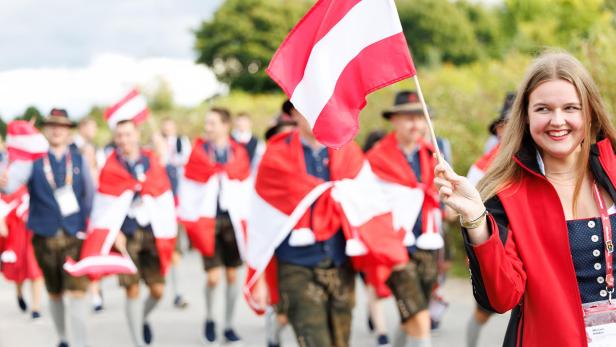 Team Austria spaziert auf einr Staße - alle mit rot-weiß-roten Fahnen