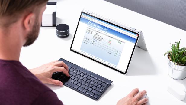 Businessman's Hand Pointing The Online Banking Form On Laptop Businessman's Hand Pointing The Online Banking Form On Laptop