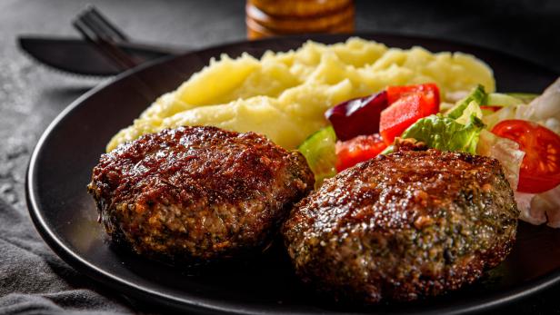 Faschiertes Laibchen mit Kartoffelpüree auf einem Teller
