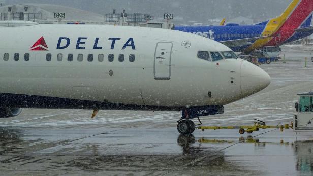 Ein Symbolbild für ein Flugzeug von Delta, das am Flughafen im Regen steht 