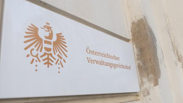 Ein Schild mit dem österreichischen Bundesadler und der Aufschrift „Österreichischer Verwaltungsgerichtshof“ an einer Wand.