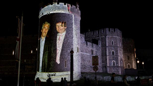 Trump und Epstein werden nachts groß auf die Außenmauer von Schloss Windsor projiziert, während Menschen davor stehen.