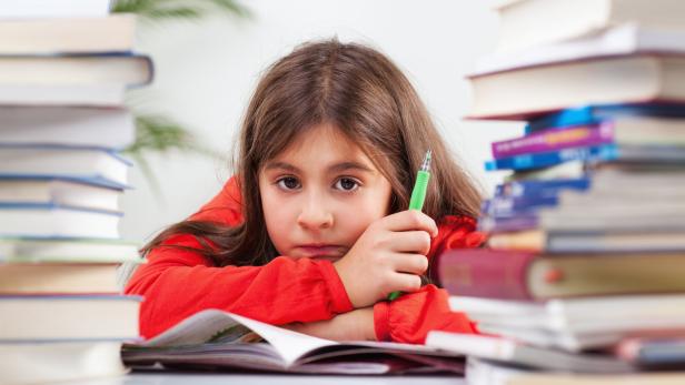 Doing Homework Ein Mädchen schaut zwischen Büchern ins Weite.