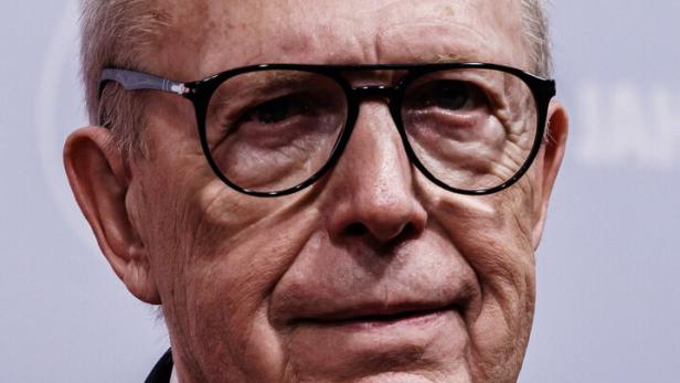 Reiner Calmund mit Brille und Anzug blickt in die Kamera.