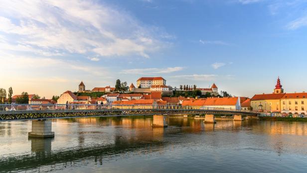 Ptuj: Fußgängerbrücke über die Drau, hinten die mittelalterliche Schlossanlage am Burghügel über der Stadt.