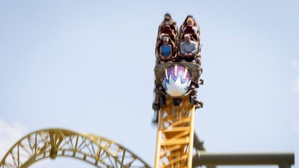 Personen sitzen im Waggon der Achterbahn "Stardust Racers" im Themenpark "Epic Universe" in Florida.