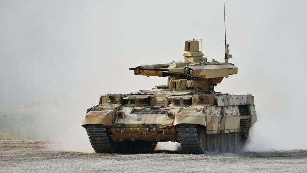 Ein BMPT Terminator-1 Kampfpanzer fährt durch staubiges Gelände.