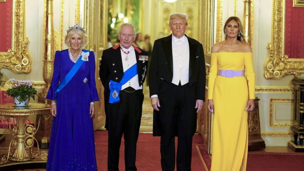 Donald Trumps Staatsvisite in England.jpg König Charles, Camilla, Donald Trump und Melania Trump posieren in festlicher Kleidung in einem prunkvollen Raum.