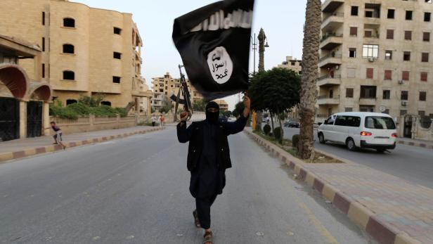 A member loyal to the ISIL waves an ISIL flag in Raqqa A member loyal to the ISIL waves an ISIL flag in Raqqa