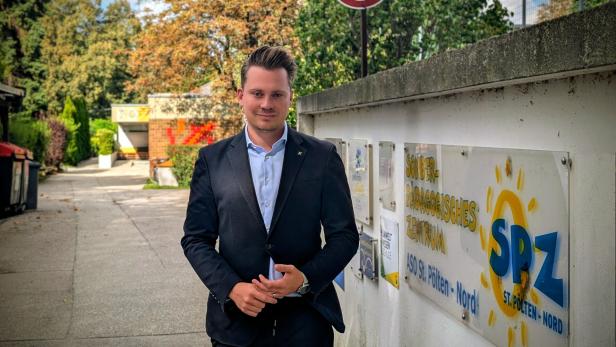 Ein Mann steht auf einer Straße und schaut in die Kamera