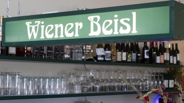 Ein Schild mit der Aufschrift „Wiener Beisl“ hängt über einer Bar.