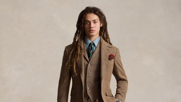 Ein Mann mit Dreadlocks trägt ein Tweed-Sakko und eine passende Weste.
