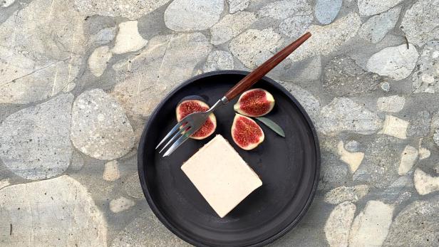 Ein Teller mit Kuchen und Feigen mit einer Gabel.