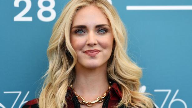 Chiara Ferragni trägt eine rot-schwarze Jacke und goldene Ketten.
