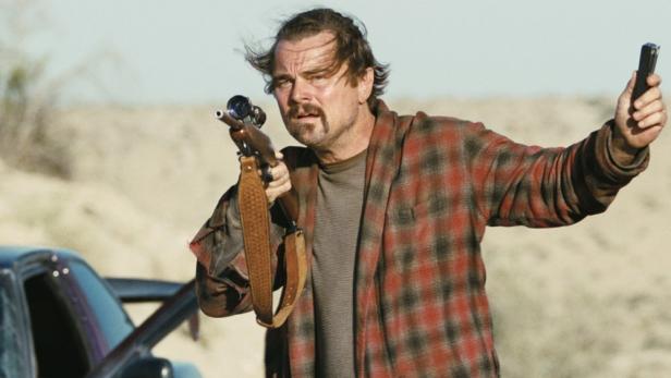 Leonardo DiCaprio hält in Filmszene ein Gewehr hoch
