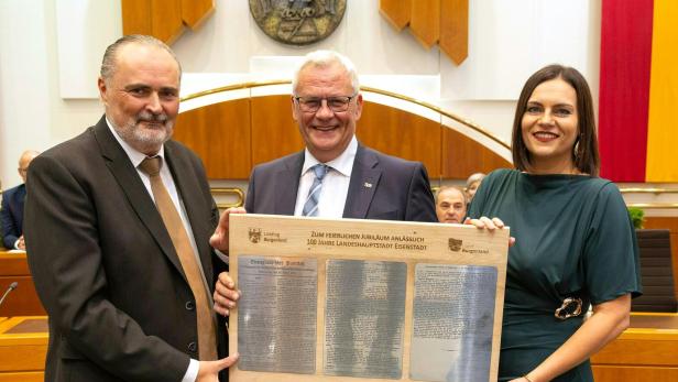 Hans Peter Doskozil, Thomas Steiner und Astrid Eisenkopf mit dem stenografischen Protokoll auf einer Holztafel