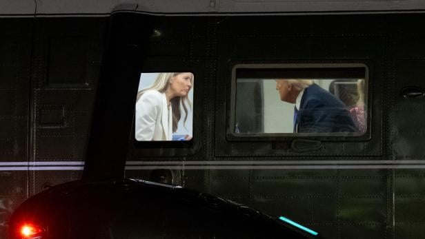 Durch Fenster eines dunklen Flugzeugs sind Melania in Weiß und Donald Trump zu sehen.