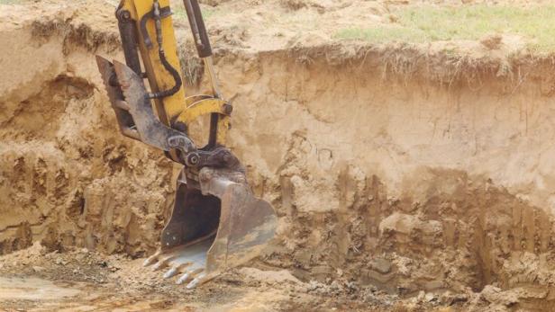 Excavator working bucket moving for foundation in construction site on earthworks
