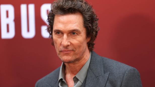 Matthew McConaughey vor rotem Hintergrund mit Schriftzug.