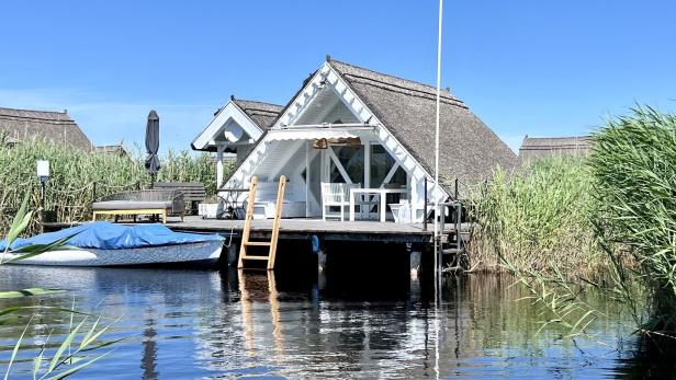 Seehütte direkt am Neusiedlersee mit Boot, das vor der Terrasse ankert