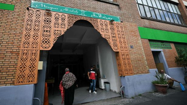 Eine Frau betritt die Moschee Al-Islah durch einen verzierten Eingang.