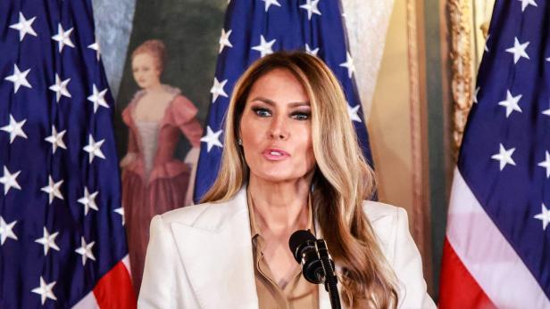 Melania Trump spricht vor US-Flaggen und einem Gemälde.