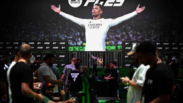 Auf einer Veranstaltung spielen Leute das neue EA Sports FC 25 vor einem großen Bildschirm.