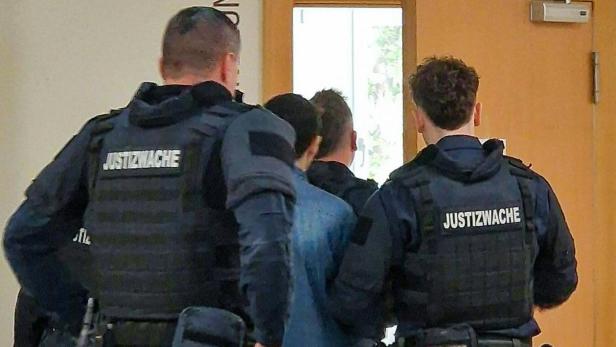 Polizisten und Menschen vor einem Gerichtssaal