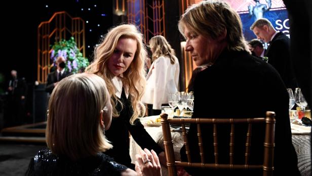 Nicole Kidman und Keith Urban sitzen an einem Tisch während einer Veranstaltung.