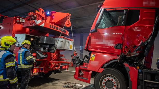 Zwei Lkw nach einem Zusammenstoß mit Feuerwehrmännern