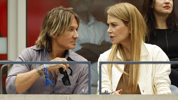 Keith Urban und Nicole Kidman sitzen nebeneinander und schauen sich an.