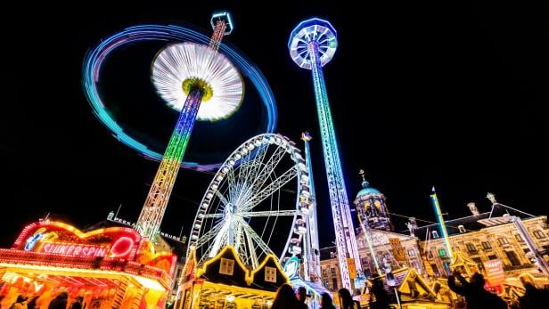 Leuchtende Fahrgeschäfte in einem Vergnügungspark bei Nacht