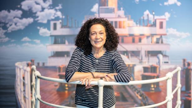 Schauspielerin Barbara Wussow im gestreiften Shirt lehnt an einer Reling vor einem Schiffsmodell der Titanic