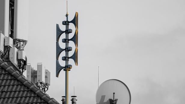 Auf einem Dach befindet sich eine Sirene mit mehreren Schalltrichtern und Antennen.