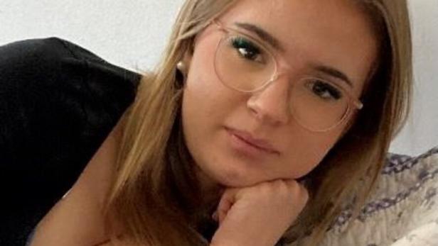 Mädchen mit blonden Haaren, Brille und schwarzem Pullover
