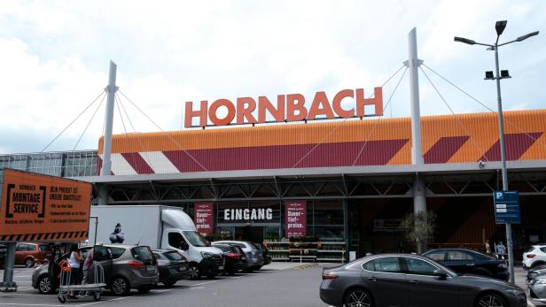 Ein Hornbach-Baumarkt mit Parkplatz und dem Schriftzug "Eingang" ist bei Tageslicht zu sehen.