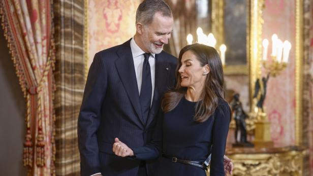 König Felipe und Königin Letizia stehen in einem eleganten Raum und schauen einander an.