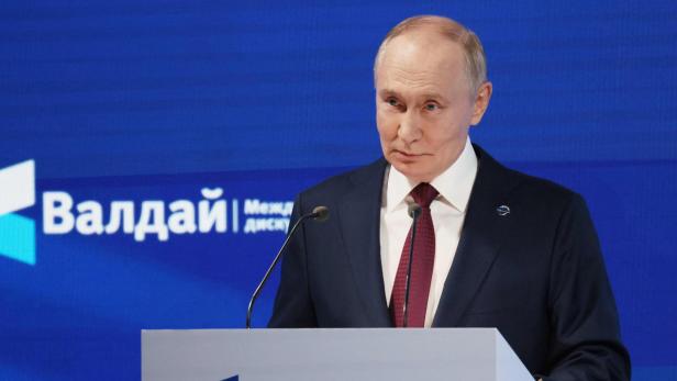 Wladimir Putin spricht vor dem Hintergrund des "Waldai"-Logos an einem Rednerpult.