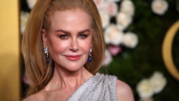 Nicole Kidman mit hochgesteckten blonden Haaren und silbernem Kleid lächelt in die Kamera.