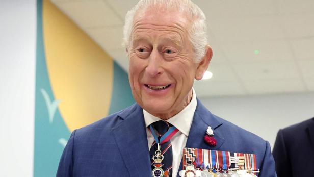 König Charles III. trägt einen blauen Anzug mit Orden und Medaillen.