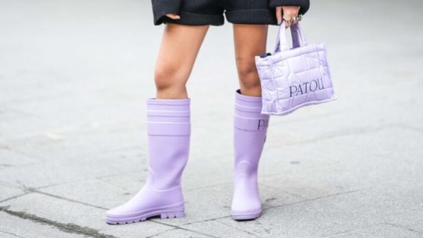 Model posiert mit lila Gummistiefeln von der Marke Patou