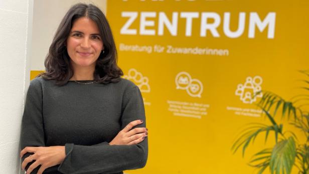 Die Leiterin des Frauenzentrums vor einer gelben Werbewand