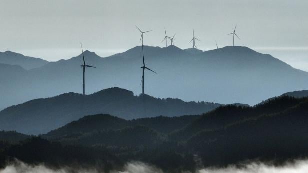 Windkraftwerke in chinesischer Hügellandschaft.