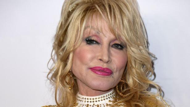 Eine Nahaufnahme von Dolly Parton mit blonden, toupierten Haaren und auffälligem Make-up.