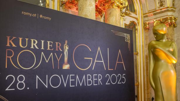 KURIER Romy 2025, Präsentation Nominierte, Pressekonferenz, PK, Palais Coburg Ein großes Schild kündigt die Kurier Romy Gala am 28. November 2025 an, daneben steht eine goldene Statue.