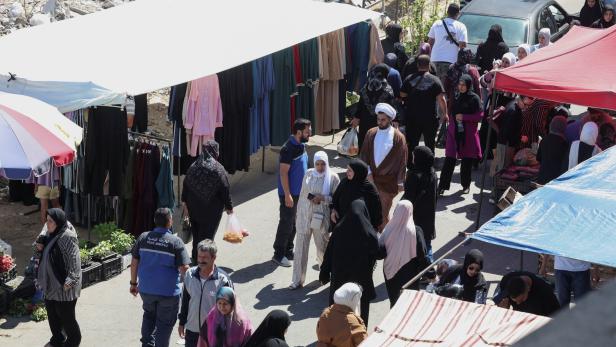 People walk at Nabatieh market that reopened after it was destroyed during the last war between Israel and Hezbollah, in Nabatieh