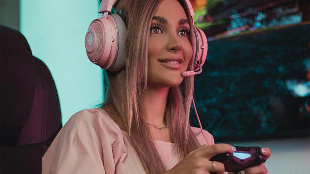 Frau in Katzenkostüm und Joystick in der Hand