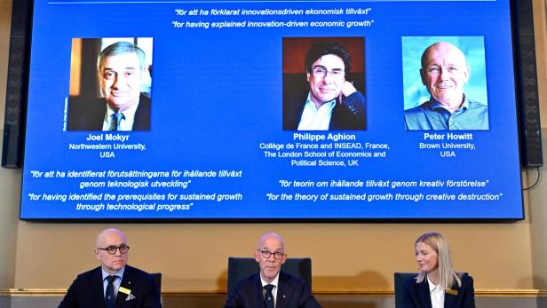 Nobelpreis-Kommittee mit Abbildung der drei Preisträger für Wirtschaftswissenschaften 2025.